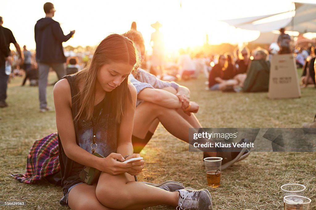 Young woman tjecking smartphone at festival