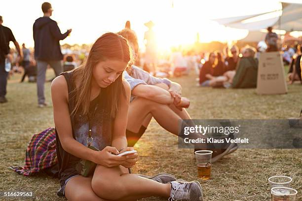 young woman tjecking smartphone at festival - outside lands music arts festival stock pictures, royalty-free photos & images
