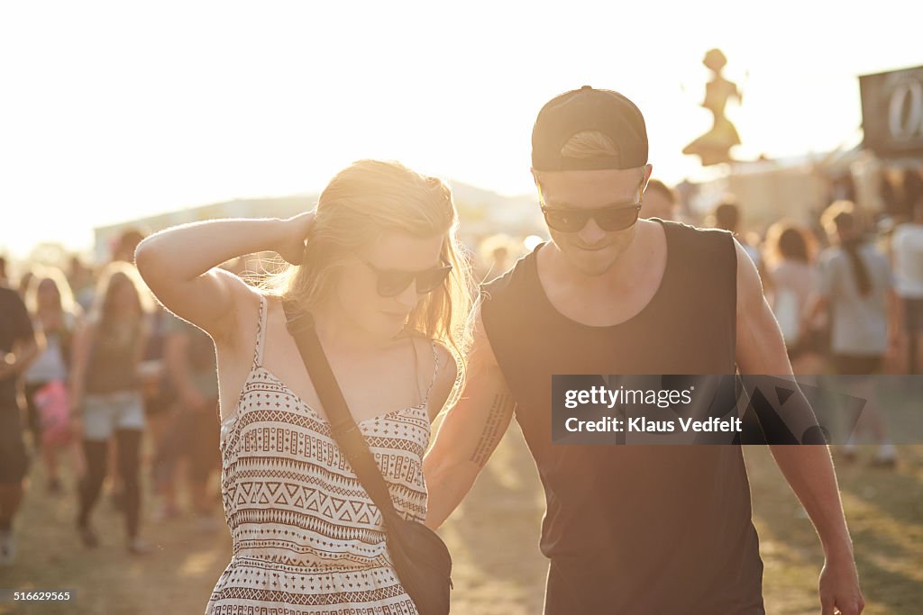 Young couple walking together at festival