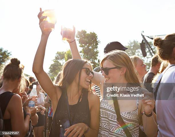girlfriends cheering with beer at concert outside - drinking beer festival stockfoto's en -beelden