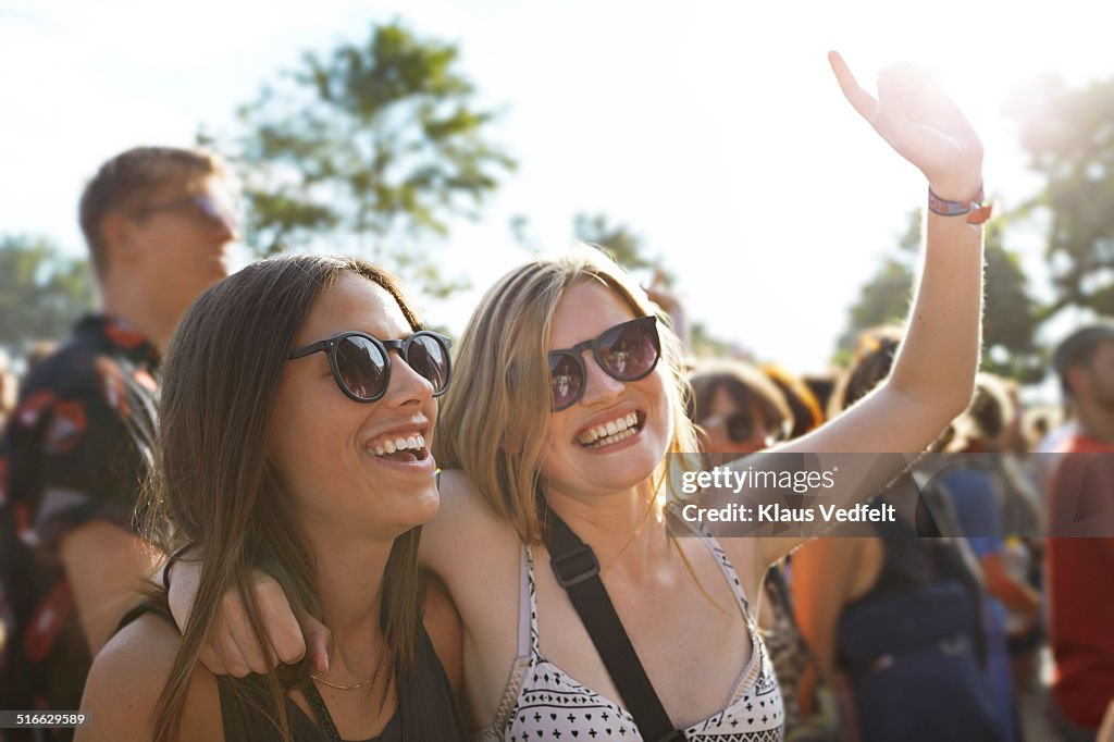 2 girlfriends cheering at concert outside