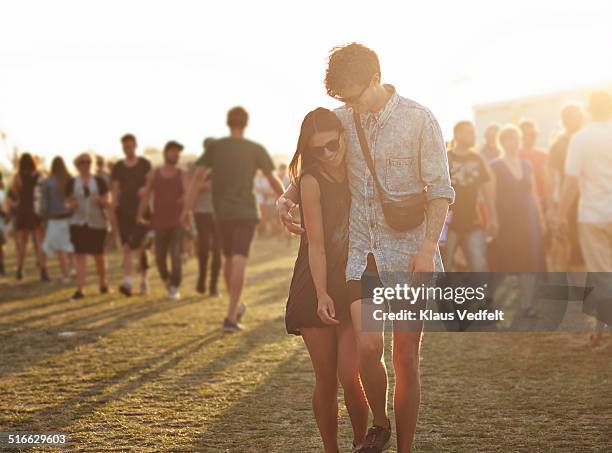 young couple walking together at music festival - large group of people field stock pictures, royalty-free photos & images