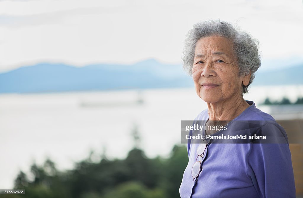 Independent Senior Asian Woman Enjoying View from Apartment, Vancouver, Canada