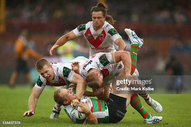 Ben Creagh and Will Matthews of the Dragons tackle Jason Clark of the Rabbitohs during the round three NRL match between the St George Dragons and...