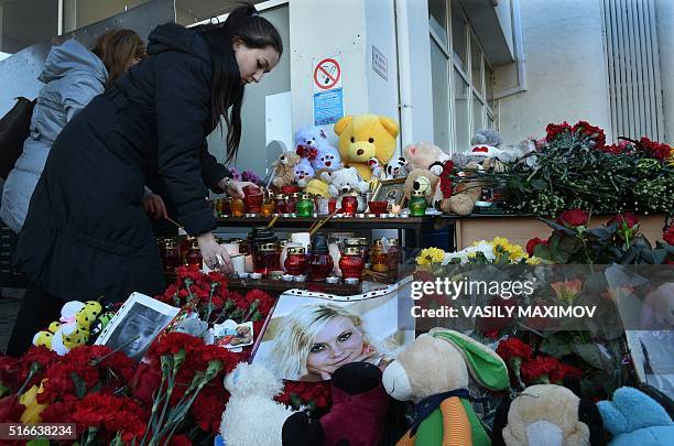 Woman lays flowers at the Rostov-on-Don airport entrance on March 20, 2016. A flydubai passenger Boeing jet crashed early Saturday as it attempted to...