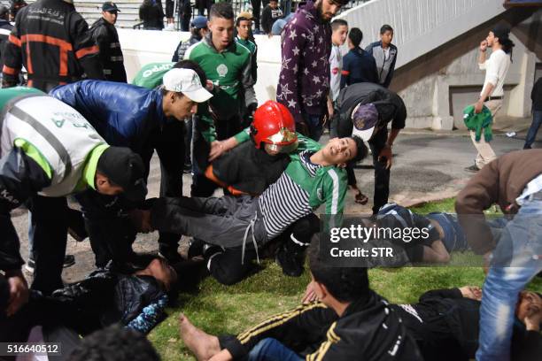 Moroccan youths lie on the pitch of the the Mohammed V stadium in Casablanca on March 19 following clashes between rival fans of Raja de Casablanca...