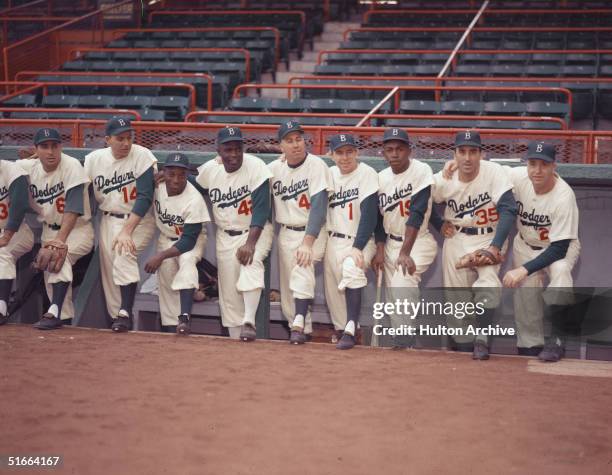 Portrait of members of the Brooklyn Dodgers baseball team pose in the dugout, 1954. From left, Americans Carl Furillo and Gil Hodges , Cuban Sandy...