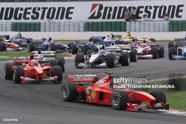 German Ferrari driver Michael Schumacher leads the pack exiting the chicanes after the start of the Malaysian Grand Prix at the Sepang International...