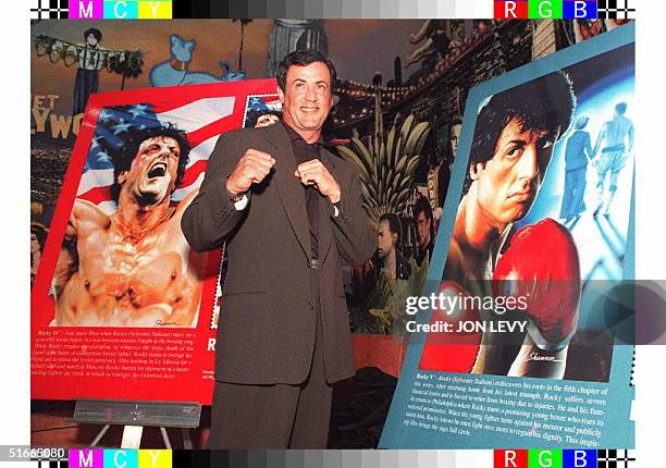Actor Sylvester Stallone poses for photographers in front of two replicas of new postage stamps featuring Stallone in the Rocky movies 21 November in...