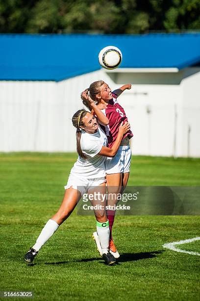 two attractive female soccer players engage in header battle - heading the ball stock pictures, royalty-free photos & images