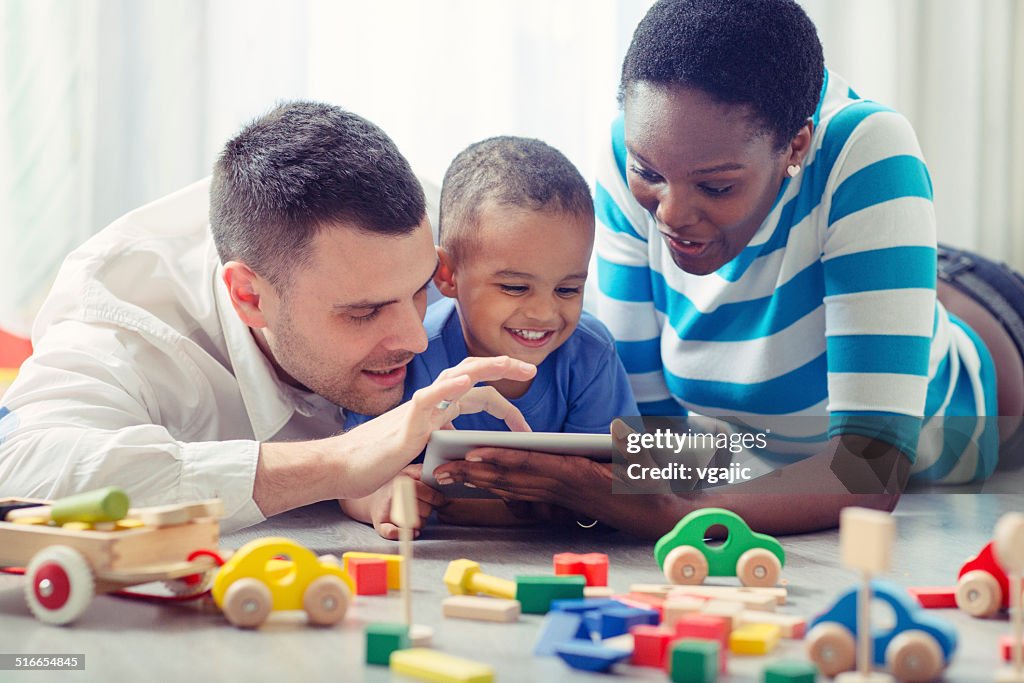 Multi-ethnic Family with one child having fun with digital tablet.