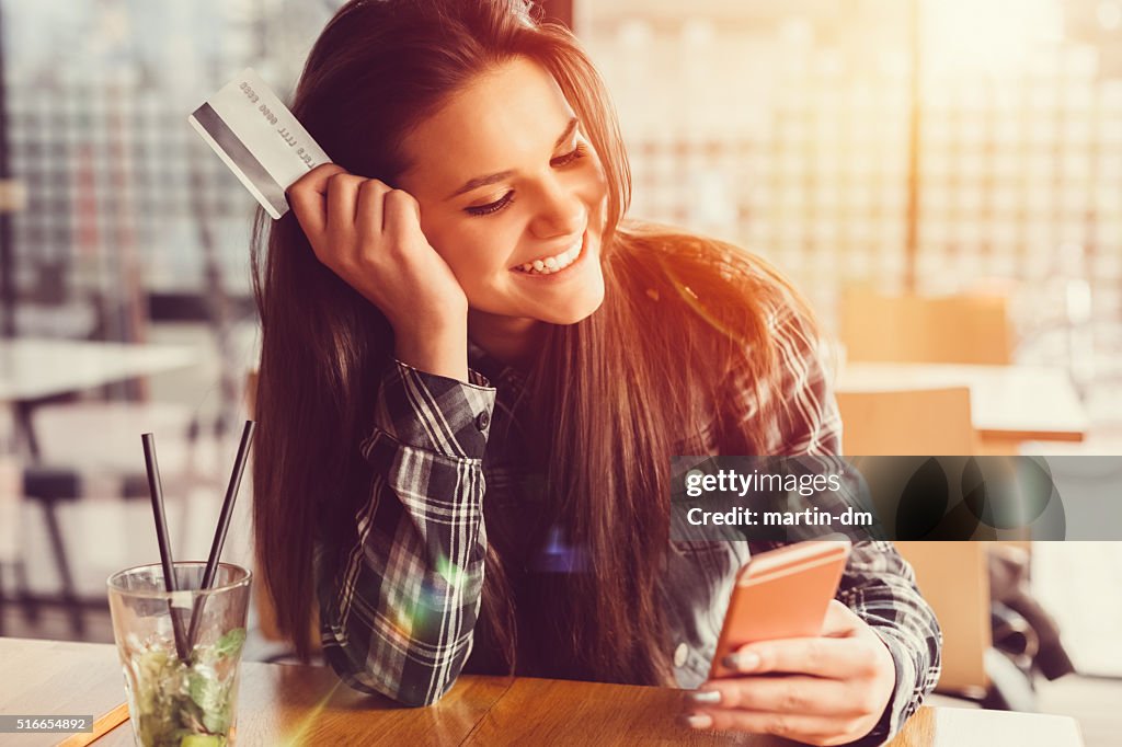 Girl holding credit card and texting