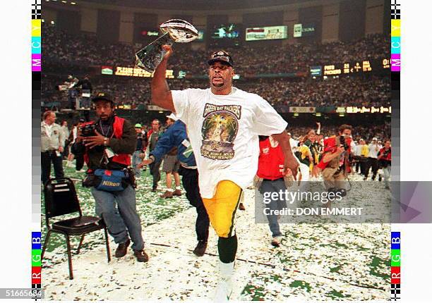 Green Bay Packers defensive tackle Reggie White carries the Vince Lombardi trophy around the field at the Louisiana Superdome after Green Bay won...