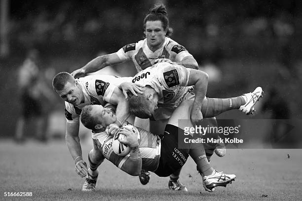 Ben Creagh, Mitch Rein and Will Matthews of the Dragons tackle Jason Clark of the Rabbitohs during the round three NRL match between the St George...