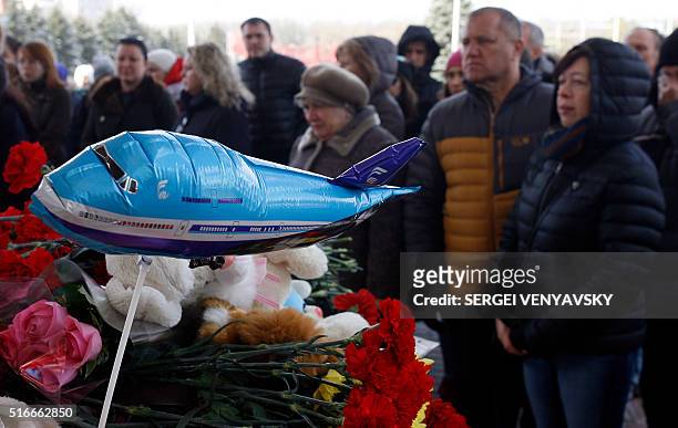 People pay their tribute to victims of the airplane crash in front of a makeshift memorial at the entrance of the Rostov-on-Don airport, on March 20,...