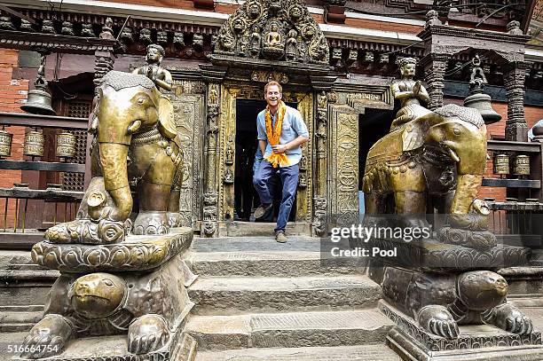 Prince Harry enters Hiranya Varna Mahavihar, know locally as the Golden Temple, during the second day of his tour of Nepal on March 20, 2016 in...