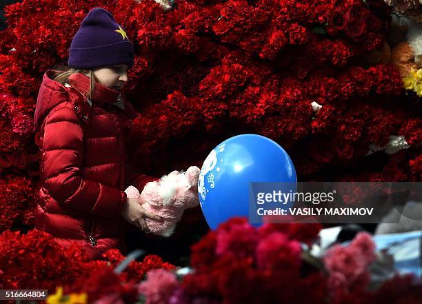 Girl lays a toy as she pays a tribute to victims of an air-crash at the Rostov-on-Don airport entrance on March 20, 2016. A flydubai passenger Boeing...