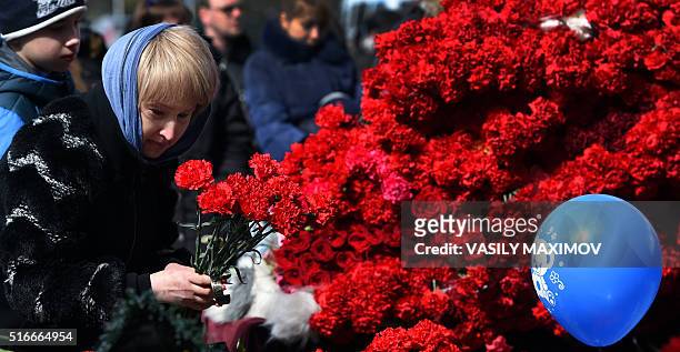 Woman lays flowers to pay a tribute to the victims of an air-crash at the Rostov-on-Don airport entrance on March 20, 2016. A flydubai passenger...
