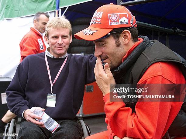Iitalian Grand Prix rider Massimiliano Biaggi listens to former World 500cc champion and team manager Wayne Rainey prior to the 500cc qualifying...