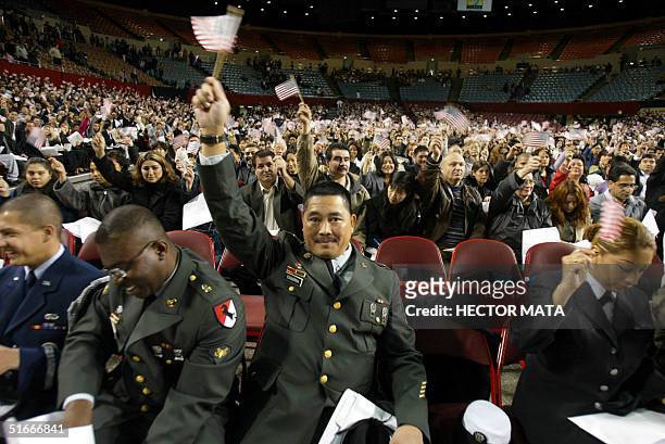 Some two thousand people wave American flags after being naturalized as US citizens by the Immigration and Naturalization Service in a ceremony in...