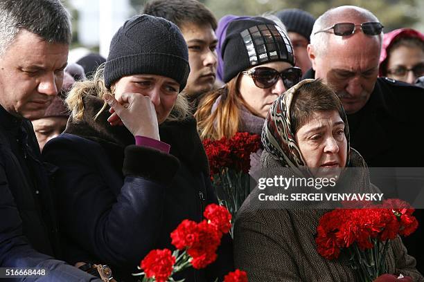 People pay a tribute to victims of an air-crash at the Rostov-on-Don airport entrance on March 20, 2016. A flydubai passenger Boeing jet crashed...