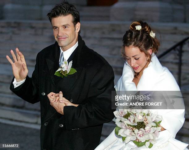Canadian singer Roch Voisine waves to fans as he and his bride Myriam St-Jean exit St. Viateur Church after their wedding, 21 December 2002 in...