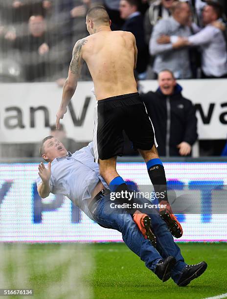 Aleksandar Mitrovic of Newcastle United collides with a fan as he celebrates scoring their first and equalising goal during the Barclays Premier...