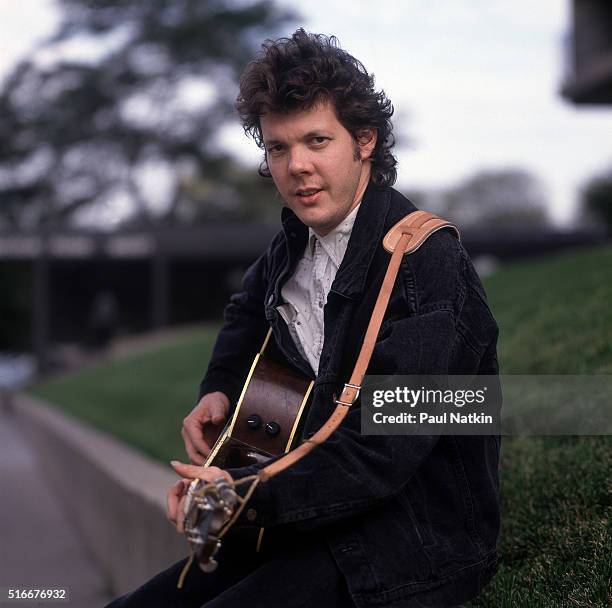 Portrait of American Folk and Pop musician Steve Forbert as he poses, with his guitar, outside the Park West Auditorium, Chicago, Illinois, October...