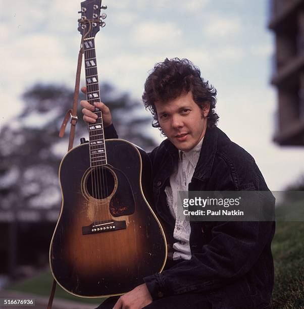 Portrait of American Folk and Pop musician Steve Forbert as he poses, with his guitar, outside the Park West Auditorium, Chicago, Illinois, October...