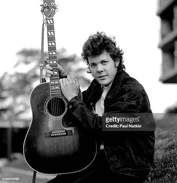 Portrait of American Folk and Pop musician Steve Forbert as he poses, with his guitar, outside the Park West Auditorium, Chicago, Illinois, October...
