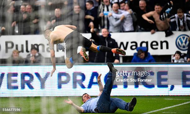 Aleksandar Mitrovic of Newcastle United collides with a fan as he celebrates scoring their first and equalising goal during the Barclays Premier...