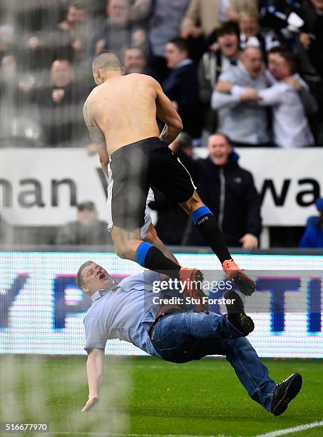 Aleksandar Mitrovic of Newcastle United collides with a fan as he celebrates scoring their first and equalising goal during the Barclays Premier...