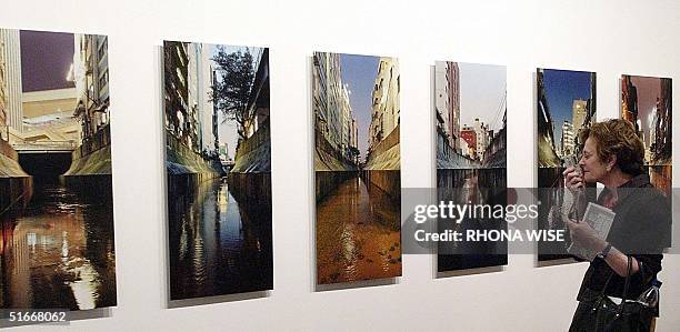 Patron photographs a picture in a series by artist Naoya Hatakeyama at the Art Basel International Art Show 06 December 2002 on Miami Beach, Florida....