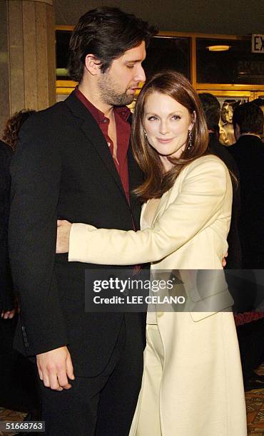 Cast member Julianne Moore hugs her husband, John Gould Rubin, after arriving for the premiere of the film "The Hours", 18 December 2002 in the...