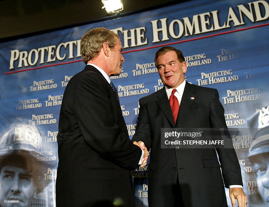 Homeland Director Tom Ridge (R) shakes hands with