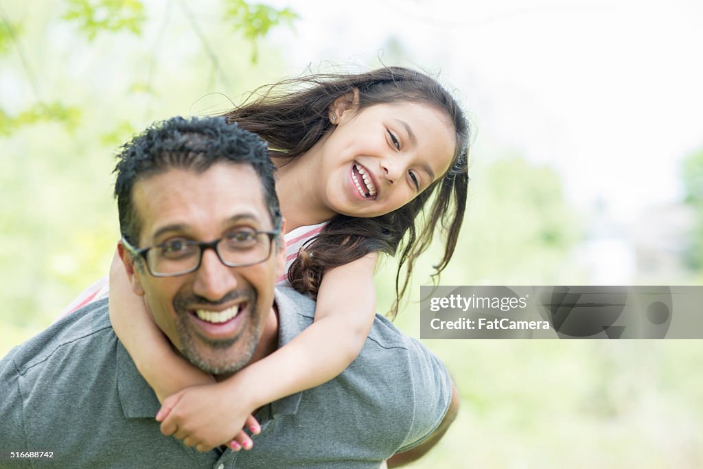 Father Giving His Daughter a Piggy Back Ride