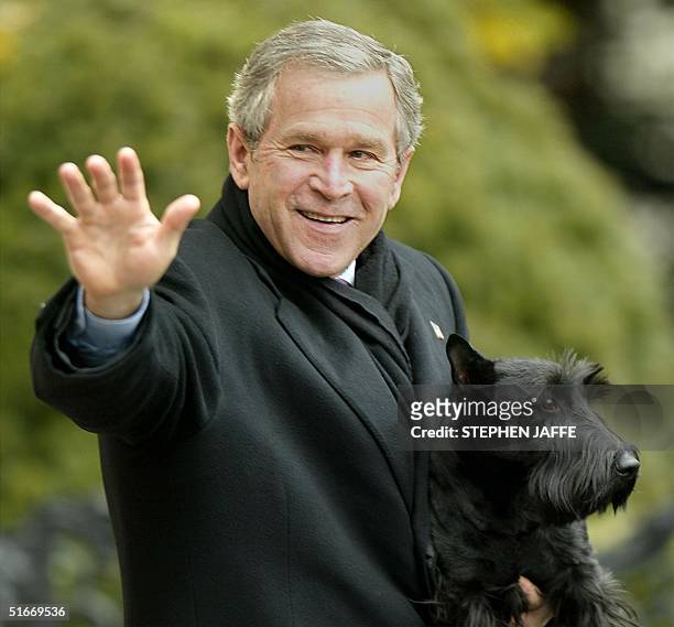 President George W. Bush holds his dog Barney as he walks to Marine One on the South Lawn of the White House enroute to Crawford, Texas for...
