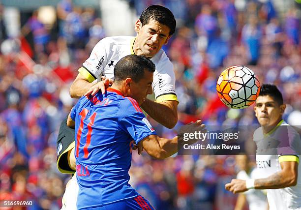 Sebastian Ubilla of U de Chile fights for the ball with Julio Barroso of Colo Colo during a match between U de Chile and Colo Colo as part of...