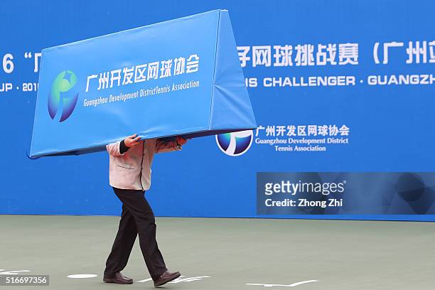 Man carrys a billboard during the 2016 ÒGDD CUPÓ International ATP Challenger Guangzhou Tour Day 6 at Guangzhou Development District International...