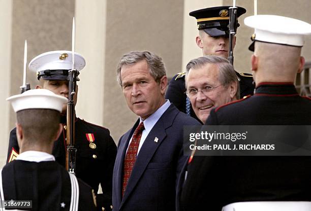 President George W. Bush and Secretary of Defense Donald Rumsfeld walk past a Honor Guard cordon on the steps of the Pentagon 02 December 2002 after...