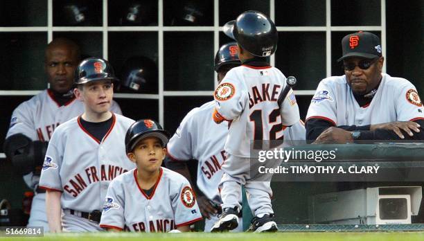 San Francisco Giants manager Dusty Baker watches his son Darren carry a bat along with Barry Bonds and some of the Giants bat boys during Game 6 of...