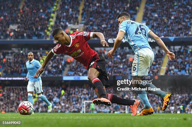 Marcus Rashford of Manchester United is challenged by Martin Demichelis of Manchester City in the penalty area during the Barclays Premier League...