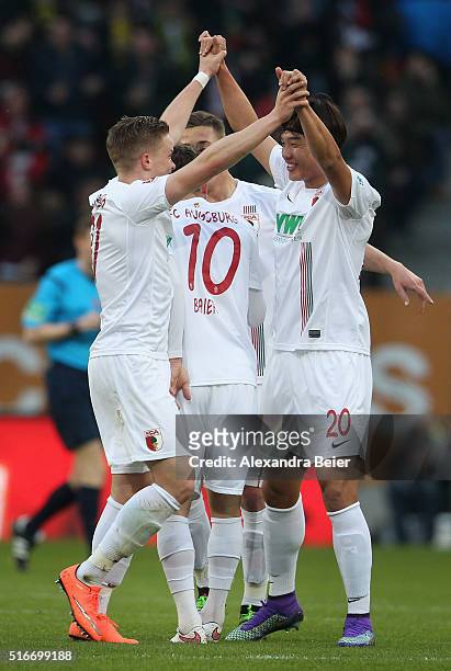Jeong-Ho Hong and Philipp Max of FC Augsburg celebrate their team's first goal during the Bundesliga match between FC Augsburg and Borussia Dortmund...