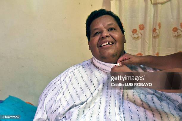 Oscar Vasquez Morales is helped to put a shirt on at his home on March 19 in Palmira, Colombia. Vasquez, who weighs about 400 kilos and is considered...
