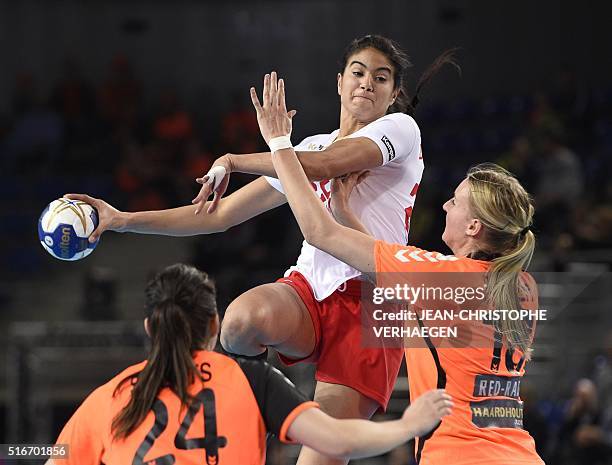 Tunisia's left back Maroua Dhaouadi challenges Netherlands' left wing Martine Smeets and Netherlands' left back Kelly Dulfer during the women's...