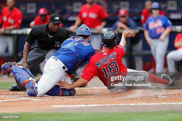 Travis d'Arnaud of the New York Mets tags David Murphy of the Boston Red Sox out at home for the final out of the first inning during a spring...
