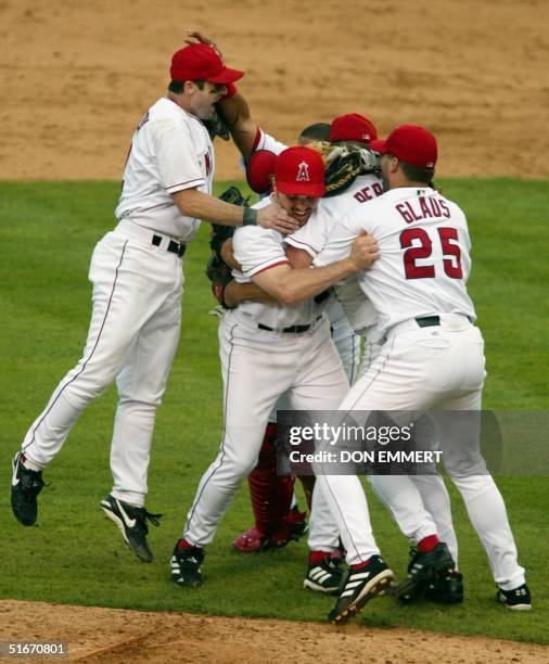 Adam Kennedy of the Anaheim Angels leaps onto his teammates after the Angels defeated the Minnesota Twins 13 October, 2002 in game 5 of the American...