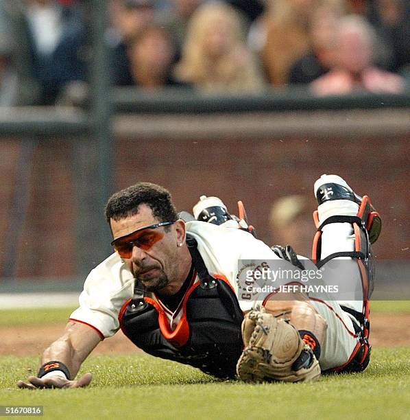 Catcher Benito Santiago of the San Francisco Giants catches a foul tip by Andy Benes of the St. Louis Cardinals during game 4 of the National League...