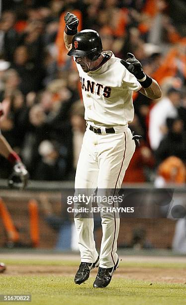 Benito Santiago of San Francisco Giants celebrates his game-winning two-run home run in the eighth inning while running down the first base line...