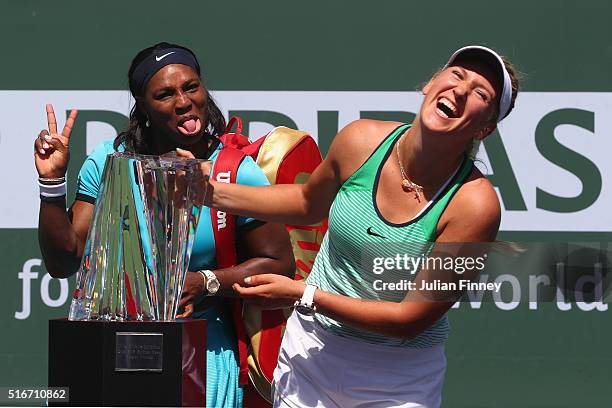 Victoria Azarenka of Belarus laughs with the winners trophy as Serena Williams of USA pulls a face after the final during day fourteen of the BNP...